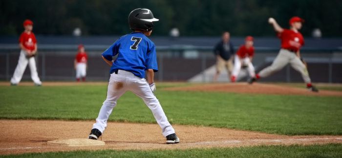 youth baseball player waiting on base